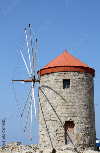 Old Greek Windmill with Blue Sky Background by The Port in Rhodes, Greece