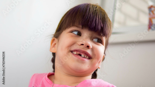 Close up portrait of a happy laughing girl without teeth enjoying good mood on light background (ID: 765446304)