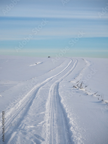 Winter evening landscape. Winter field and road in the snow. Snow and sky © Sergey