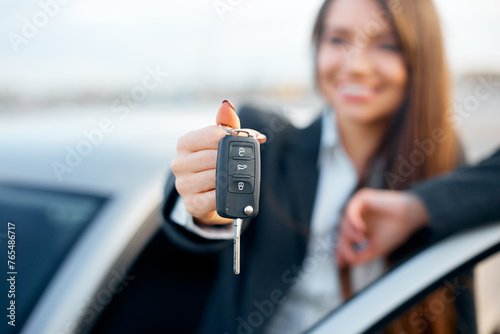 Young smiling satisfied happy female driver woman, showing close up car key.