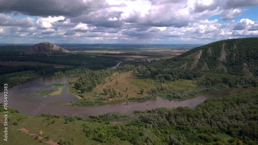Aerial view of river amidst mountains and trees under cloudy sky Aerial view of river amidst mountains and trees under cloudy sky