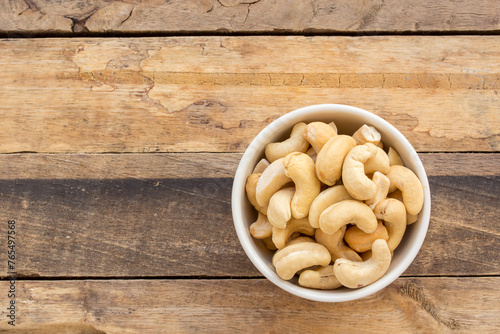 Cashew nuts in the bowl on wooden table