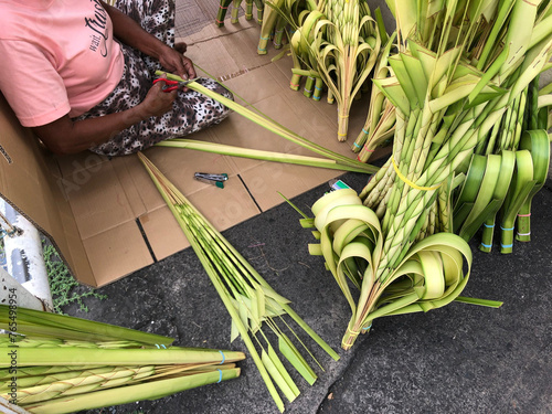Enterprising people prepare ornate handcrafted coconut palm leaves on the eve of Palm Sunday.