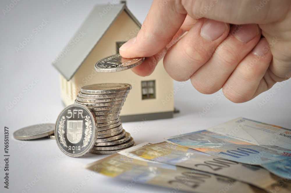 Obraz premium Finanzielle Grundlagen: Modellhaus mit Münzen und Geldscheinen
