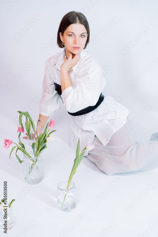 Beautiful girl in a black bodysuit with flowers on a white background Beautiful girl in a black bodysuit with flowers on a white background