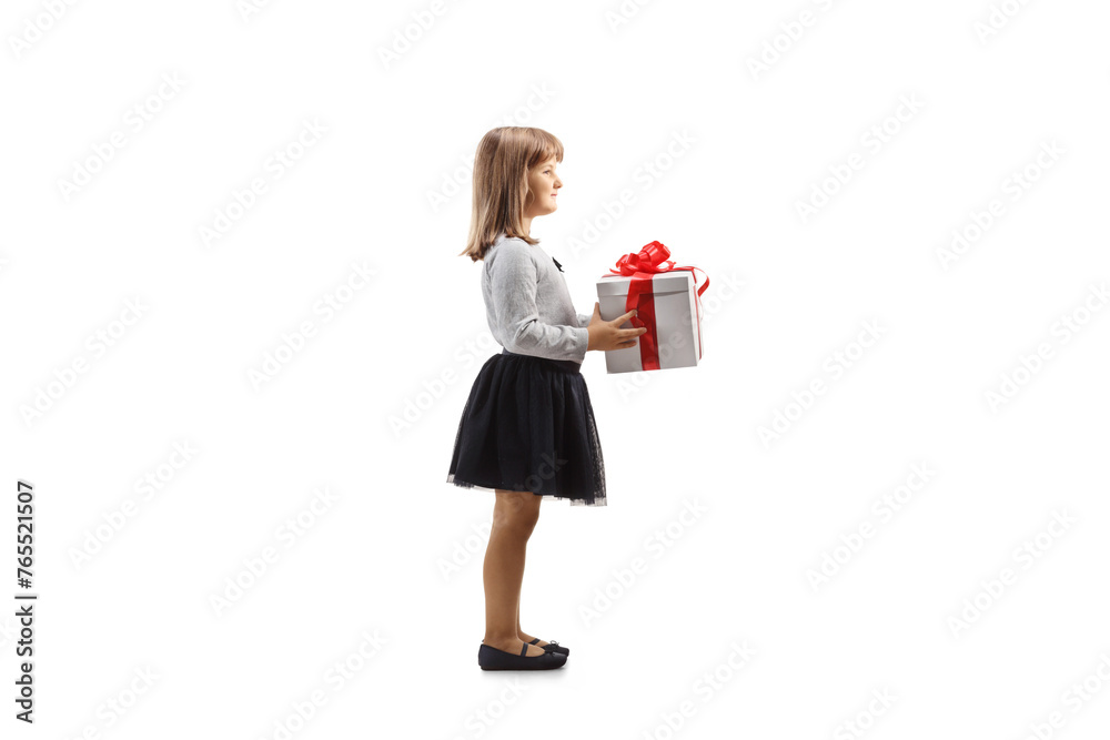 Full length profile shot of a little girl holding a gift box Full length profile shot of a little girl holding a gift box