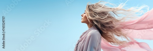 Beautiful young woman with flying hair on soft blue background, copy space for text © firax