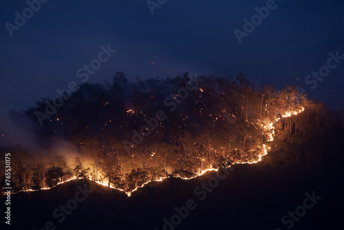 Trail of fire coming over a ridge during dusk photo