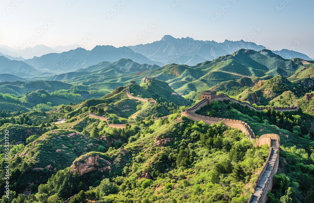 The Great Wall of China, with the sun setting in front and green mountains behind it