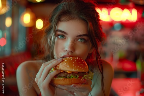Beautiful young woman having a hotdog or burger stock photo