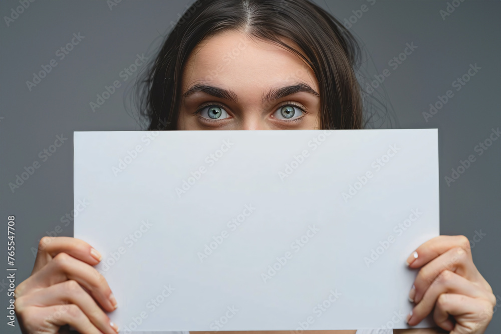 White empty sign being held by woman in front of gray background