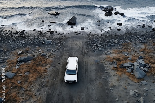 Aerial view of white car by the ocean, top-down drone shot with coastal landscape photo