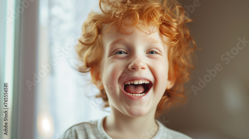 Joyful child with curly red hair laughs heartily