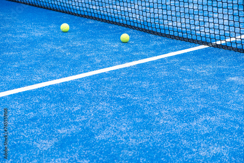 paddle tennis ball towards the net of a blue paddle tennis court © Vic