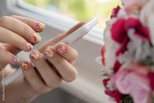 Woman manicured hands holding mobile phone, stylish summer colorful nails. Closeup of manicured nails of female hand. Summer style of nail design concept. Beauty treatment. photo