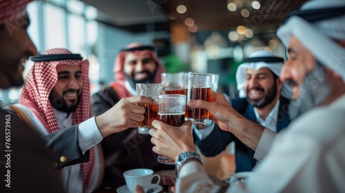 Group of Middle Eastern men cheerfully toasting drinks
