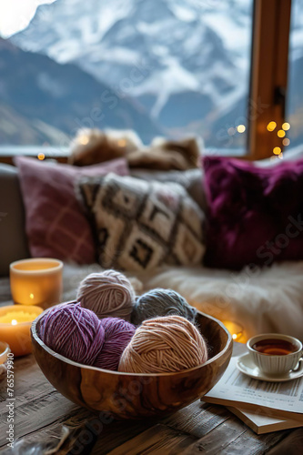 a wooden bowl with woolen yarn balls inside standing on atable in a cozy living room at christmas time, outside is an amazing mountain landscape, still life photo