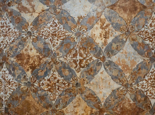 Old brown gray rusty vintage worn shabby patchwork motif tiles stone concrete cement wall texture.