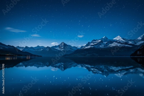 A lake reflecting the night sky with mountains in the background under a blanket of twinkling stars