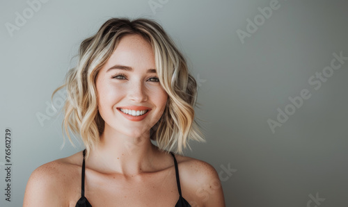 A beautiful woman with blonde hair in a bob style smiling at the camera