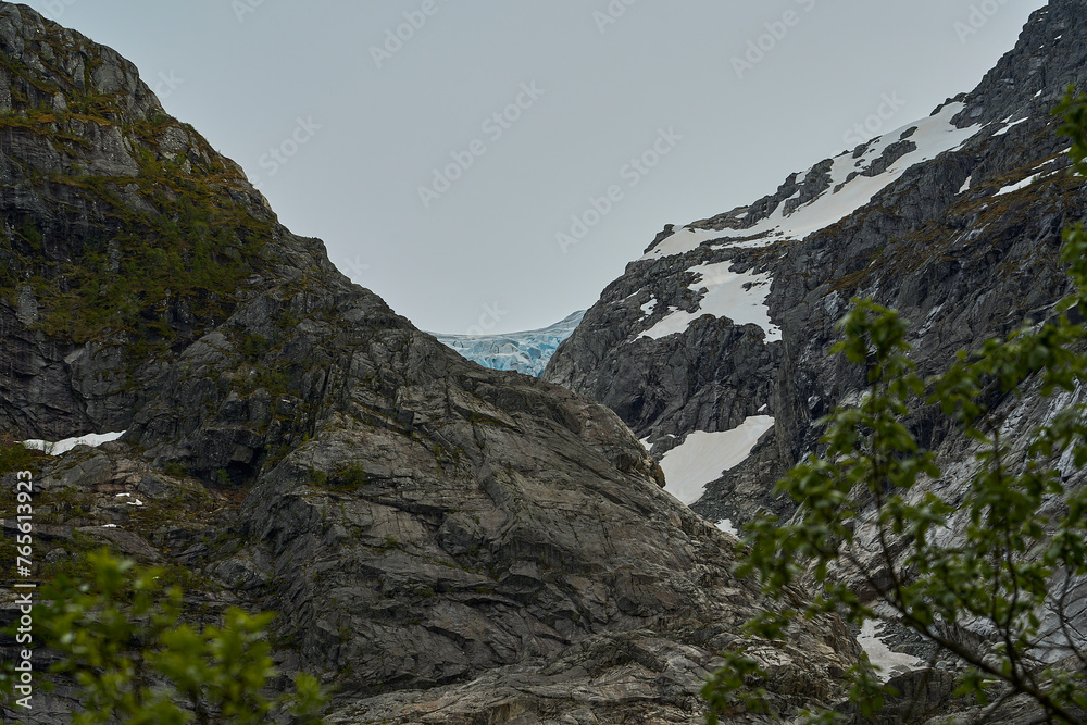 Blue Bondhusbreen Glacier hanging in the mountains over the Bondhusvatnet Lake and in Sundal, Vestland, Norway