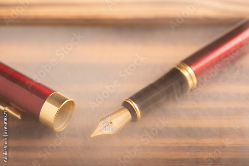Fountain pen, old and beautiful fountain pen placed on rustic wood and dark background, selective focus.