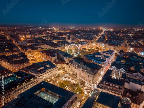 Aerial night cityscape about budapest downtown. Included the Ferris wheel, Erzsebet square, Deak square, Worosmarty square. View of illuminated streets.