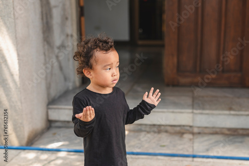 Canvas Print Lonely Asian toddler yearning as his mother leaves the home