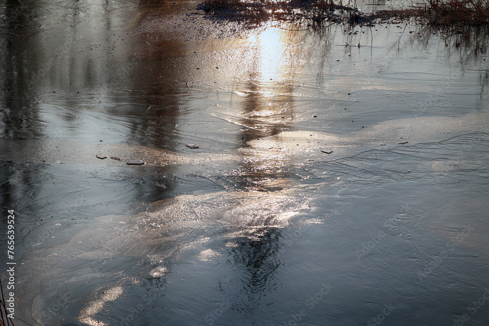 Zimowy widok na zamarzniętą wodę z kawałkami lodu.  - obrazy, fototapety, plakaty 