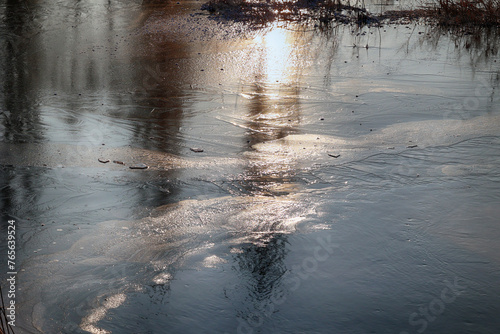 Zimowy widok na zamarzniętą wodę z kawałkami lodu. 
