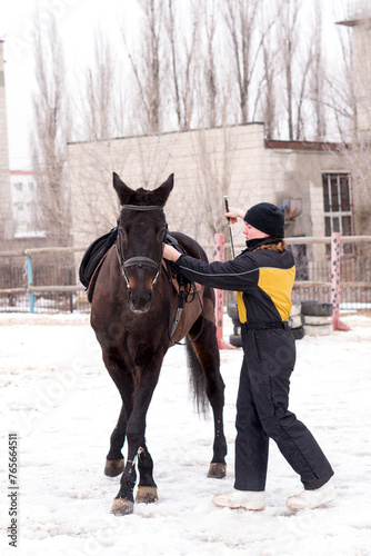 Person leading a lively horse in snow. Dressage.