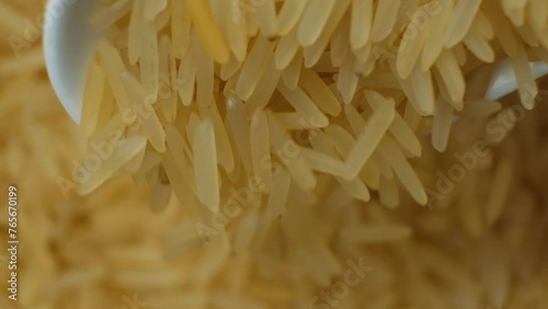 Long grain parboiled basmati rice pouring with spoon macro slow motion photo