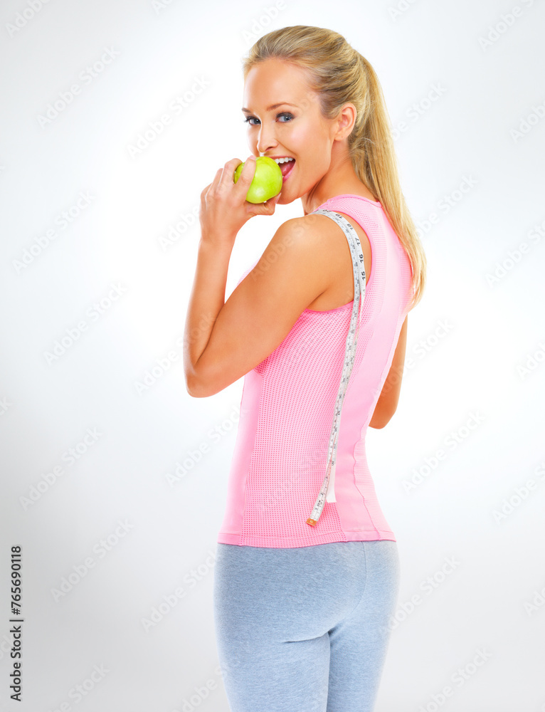 Woman, portrait and eating apple with measuring tape or lose weight diet with nutrition snack, studio or white background. Female person, face and fruit or wellness health, challenge or mockup space Woman, portrait and eating apple with measuring tape or lose weight diet with nutrition snack, studio or white background. Female person, face and fruit or wellness health, challenge or mockup space