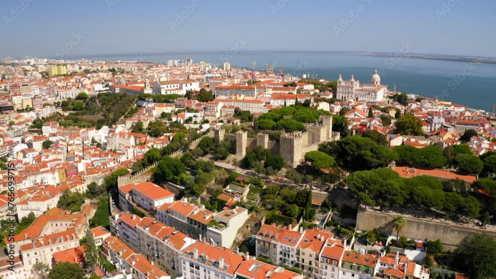 Aerial Forward Shot Of Famous Castelo De S Jorge In Residential City By Tagus River On Sunny Day - Lisbon, Portugal
