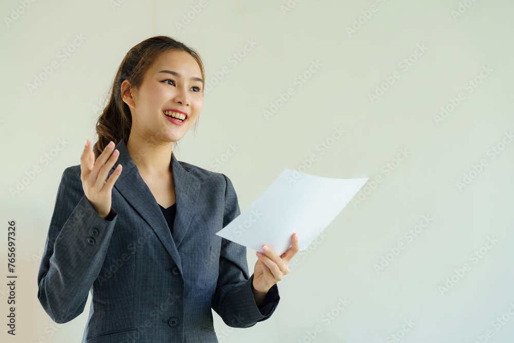 Portrait of a young Asian businesswoman holding a document paper and talking on a white background. Portrait of a young Asian businesswoman holding a document paper and talking on a white background.