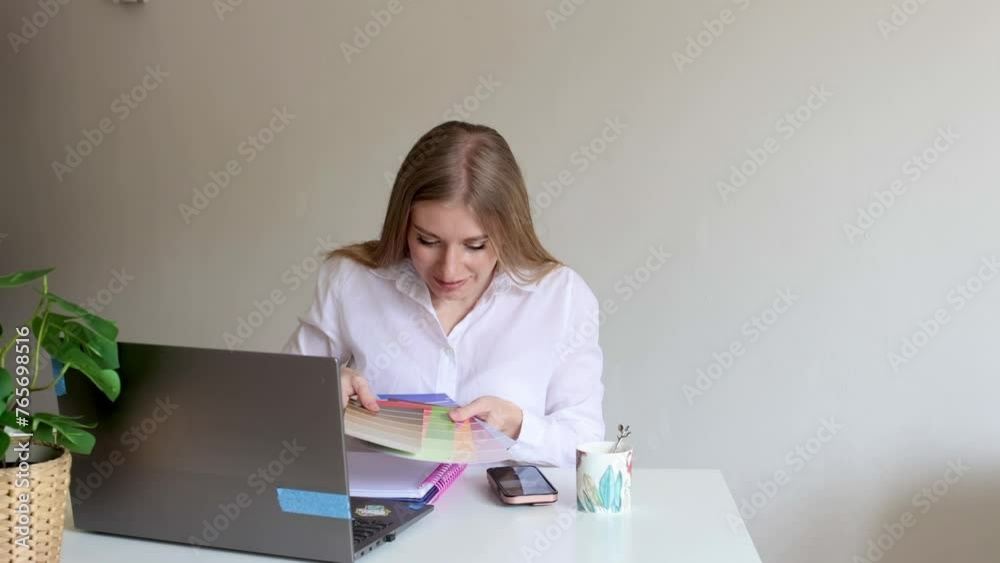 woman work on laptop and write in the note numbers of color palette woman work on laptop and write in the note numbers of color palette