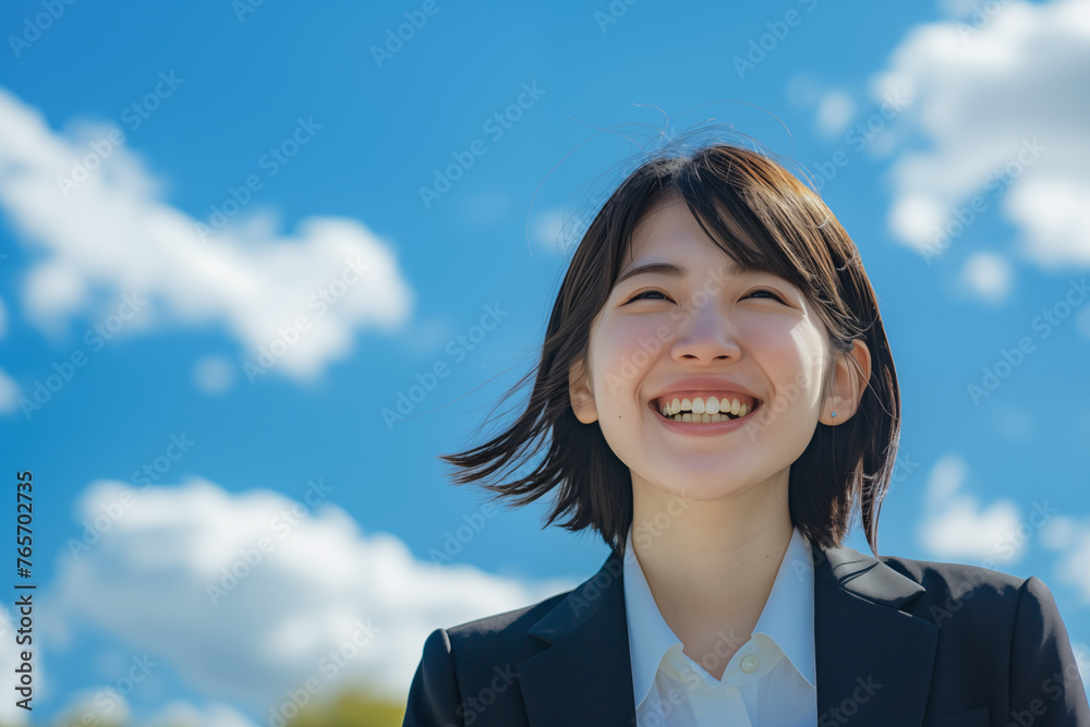 Joyful Asian businesswoman laughing under a sunny sky with clouds Joyful Asian businesswoman laughing under a sunny sky with clouds