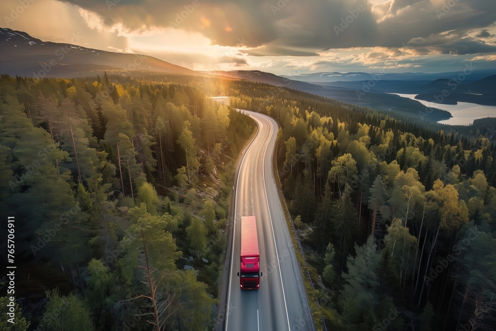 Sunset over a forest-lined highway with a truck driving, showcasing serene transportation amidst nature. - obrazy, fototapety, plakaty 