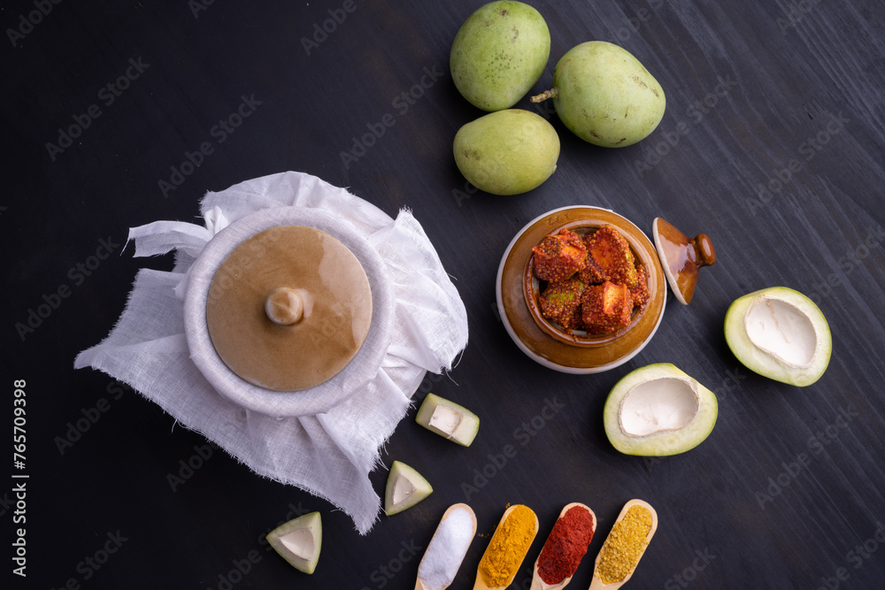Homemade Mango Pickle or aam ka achar Kairi Loncha stored or preserved in China clay pot with Ingredients. - obrazy, fototapety, plakaty 