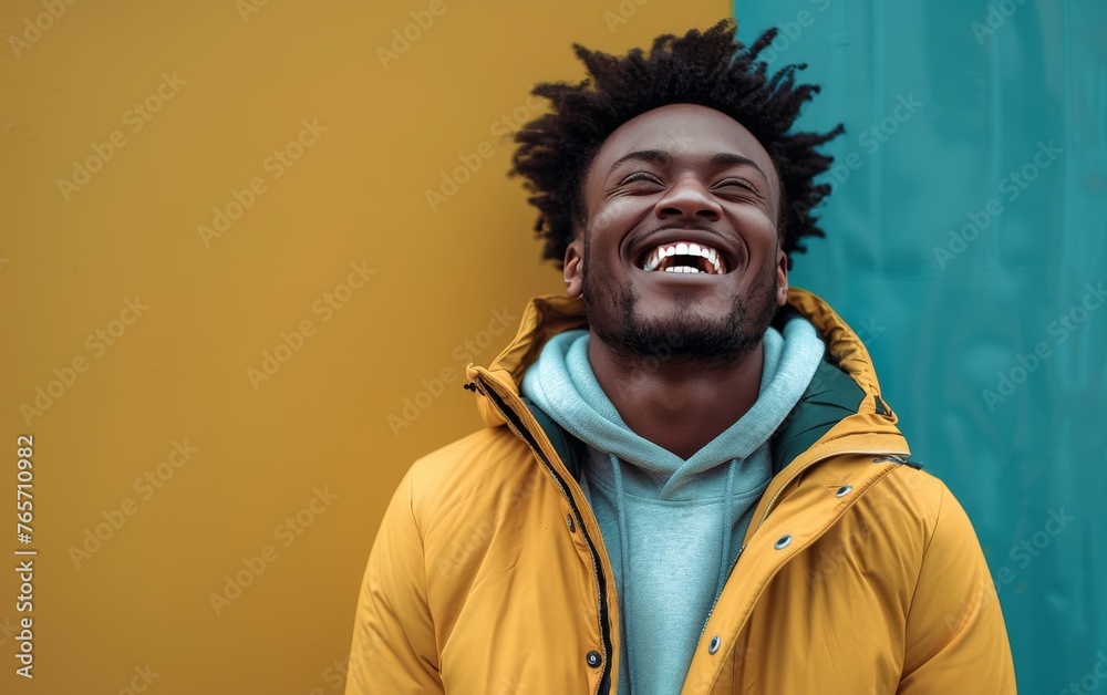 A man with a yellow hoodie is smiling and laughing A man with a yellow hoodie is smiling and laughing