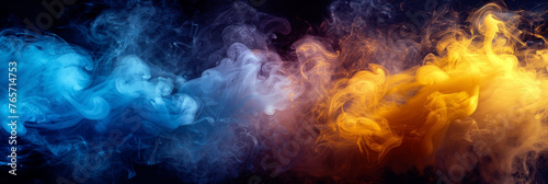 Colorful blue and yellow smoke merging and swirling while flowing on black background.
