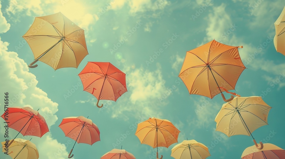 Capture a whimsical low-angle view of umbrellas against a cloudy sky, creating a dreamy and nostalgic atmosphere Enhance the image with subtle vintage tones to appeal to audiences seeking a blend