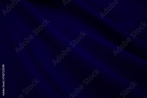 Texture of dark blue fabric closeup. Low key photo. Plexus threads. Clothing industry. Abstract background. Textile waves.