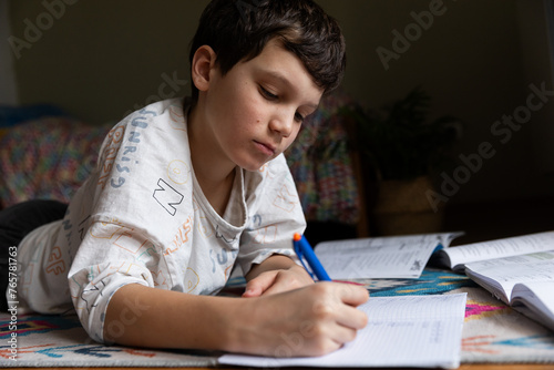 Teenager doing school homework, writing in notebooks and solving examples. School Learning Concept