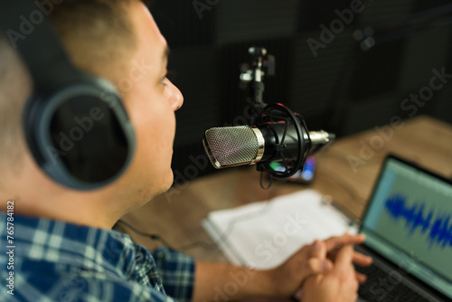 Cuadro en lienzo Hispanic podcast host with a laptop recording in the studio