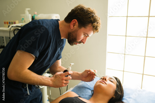 Latin therapist using moisturizer after diathermy therapy photo