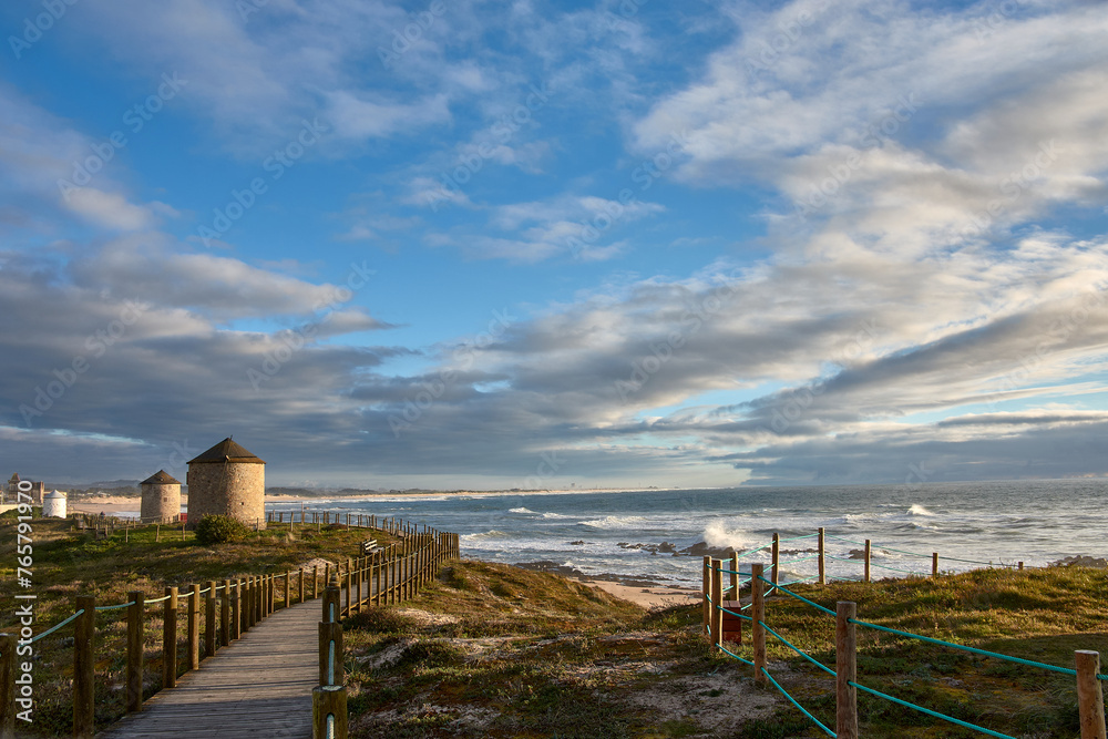 Windmills along the coastal path, Praia da Apulia beach, Portugal.