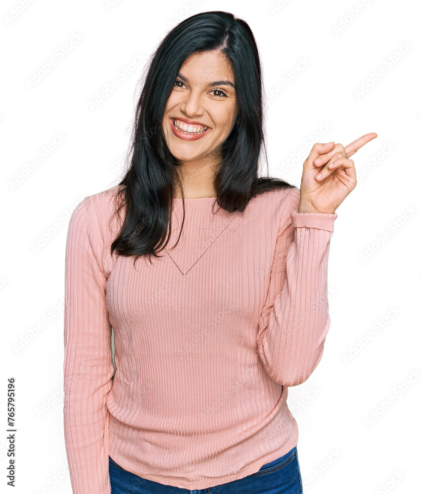 Young hispanic woman wearing casual clothes with a big smile on face, pointing with hand and finger to the side looking at the camera. Young hispanic woman wearing casual clothes with a big smile on face, pointing with hand and finger to the side looking at the camera.