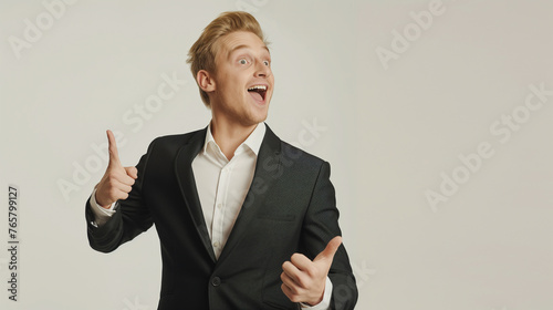 full length Surprised, cheerful handsome blond guy in classic suit, pointing left and smiling amused, hearing wonderful event nearby joyful white background professional photography.