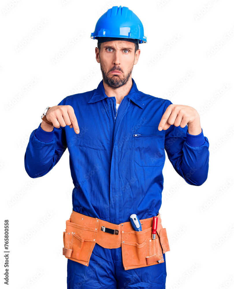 Young handsome man wearing worker uniform and hardhat depressed and worry for distress, crying angry and afraid. sad expression. Young handsome man wearing worker uniform and hardhat depressed and worry for distress, crying angry and afraid. sad expression.